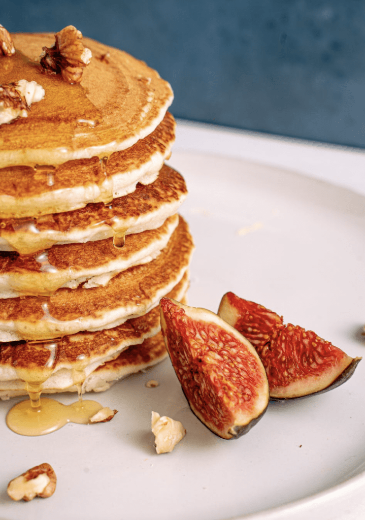 Verse luchtige pannenkoeken op een bord, gegarneerd met verse vijgen.