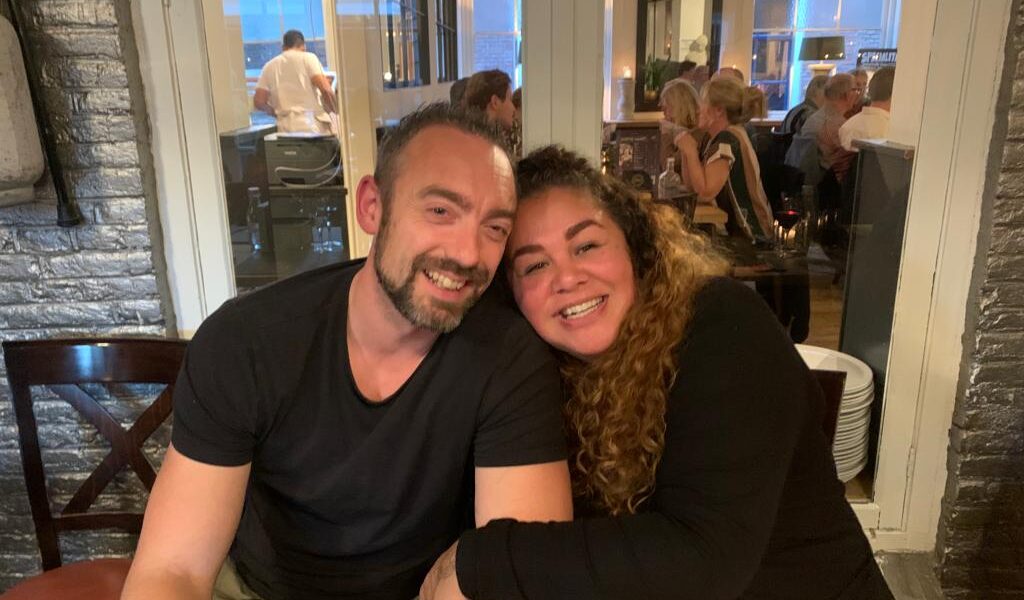 5 tips voor een sterke relatie - illustratie van een stel dat elkaar omhelst en lachend naar elkaar kijkt.