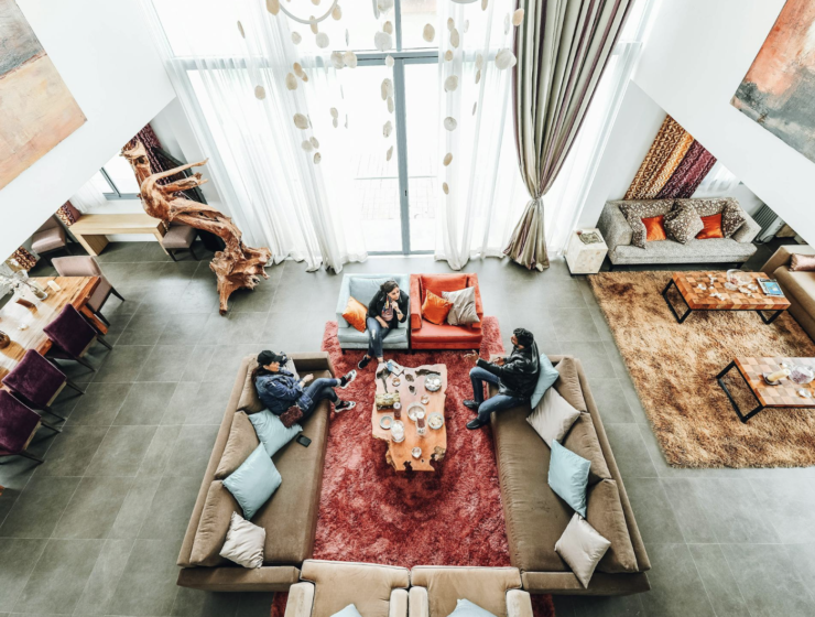 Persoon die ontspannen geniet van een comfortabele en gezellige hoek in huis, omgeven door zachte verlichting, planten en decoratieve accenten."