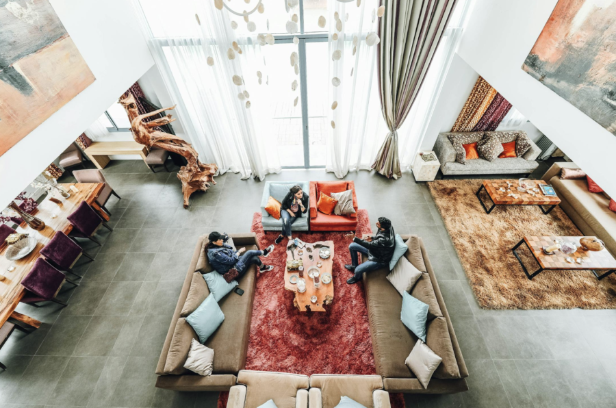 Persoon die ontspannen geniet van een comfortabele en gezellige hoek in huis, omgeven door zachte verlichting, planten en decoratieve accenten."